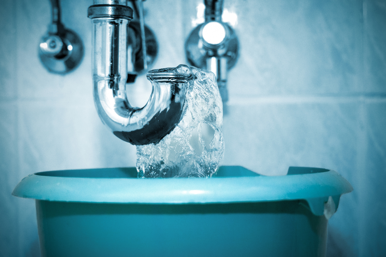 Plumber flushes the drain pipe in the bathroom